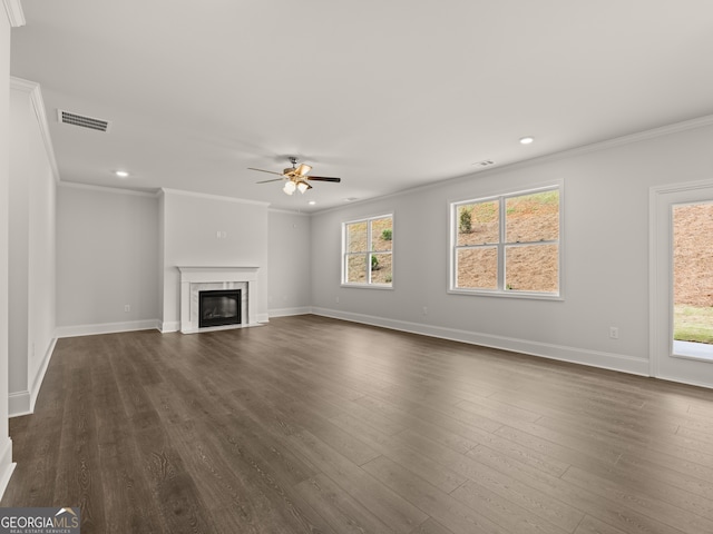 unfurnished living room with ceiling fan, dark hardwood / wood-style flooring, a premium fireplace, and ornamental molding