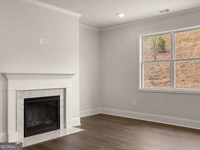 unfurnished living room featuring a high end fireplace, ornamental molding, and dark hardwood / wood-style floors