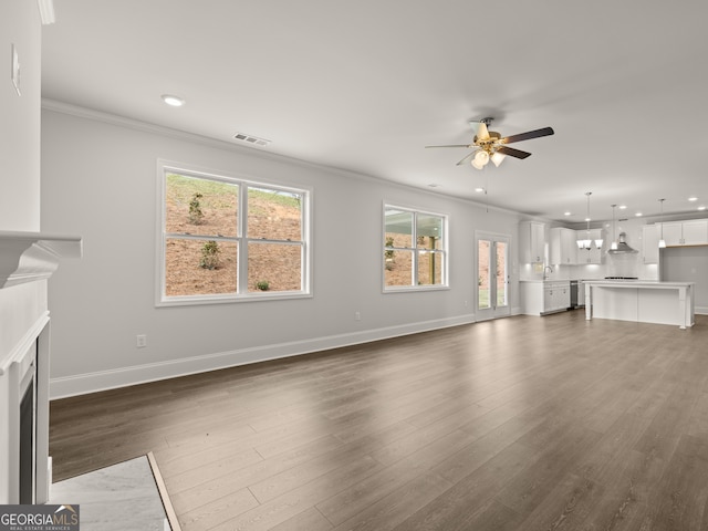 unfurnished living room with ceiling fan, sink, dark hardwood / wood-style floors, and ornamental molding