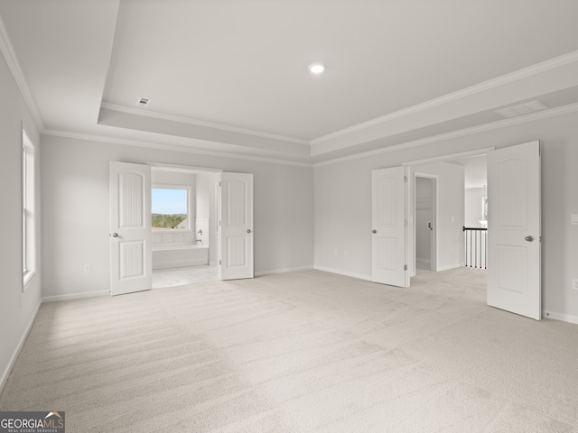 carpeted spare room with crown molding and a tray ceiling