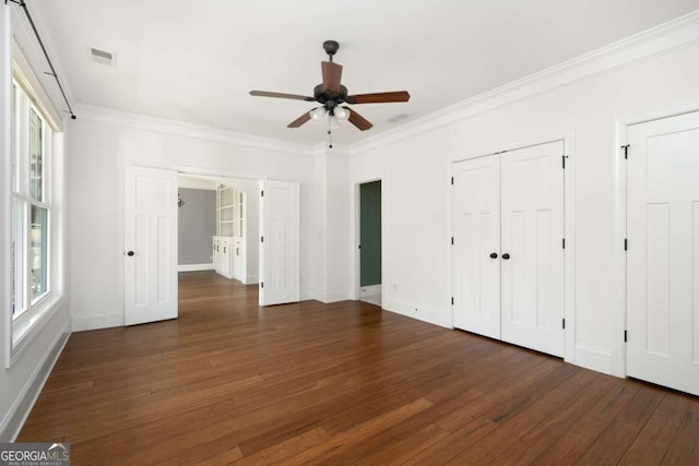 unfurnished bedroom featuring ceiling fan, ornamental molding, dark hardwood / wood-style floors, and multiple windows