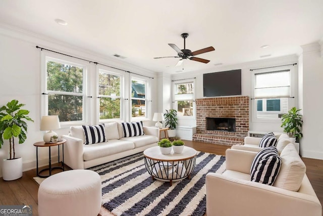 living room featuring a brick fireplace, crown molding, hardwood / wood-style floors, and ceiling fan