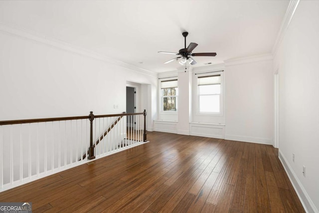 empty room with ceiling fan, dark wood-type flooring, and ornamental molding