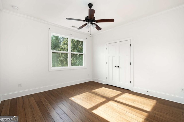 unfurnished bedroom with ceiling fan, crown molding, hardwood / wood-style floors, and a closet