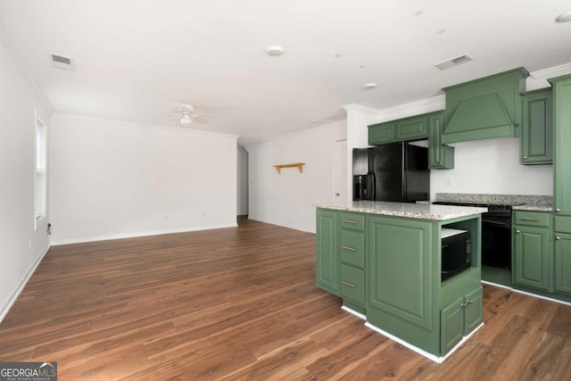 kitchen featuring green cabinets, a kitchen island, custom range hood, and black appliances