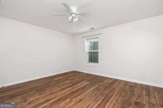 spare room featuring ceiling fan and dark wood-type flooring