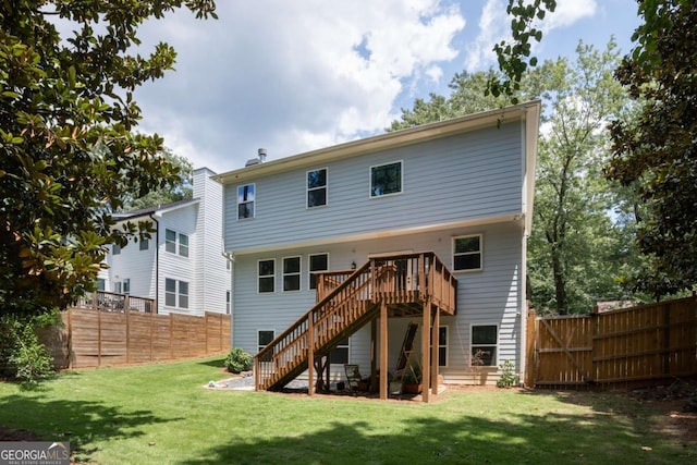 back of house with a wooden deck and a lawn