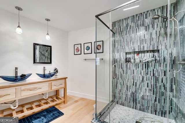 bathroom with vanity, a shower with door, and hardwood / wood-style floors