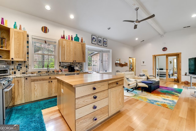 kitchen featuring wood counters, stainless steel range, light brown cabinets, tasteful backsplash, and light hardwood / wood-style flooring