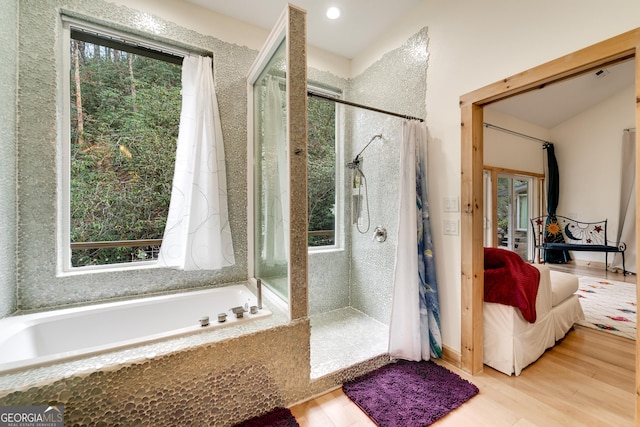 bathroom featuring plenty of natural light, shower with separate bathtub, and wood-type flooring