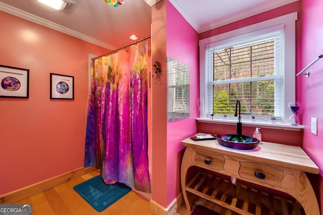 bathroom with a shower with shower curtain, crown molding, hardwood / wood-style flooring, and vanity