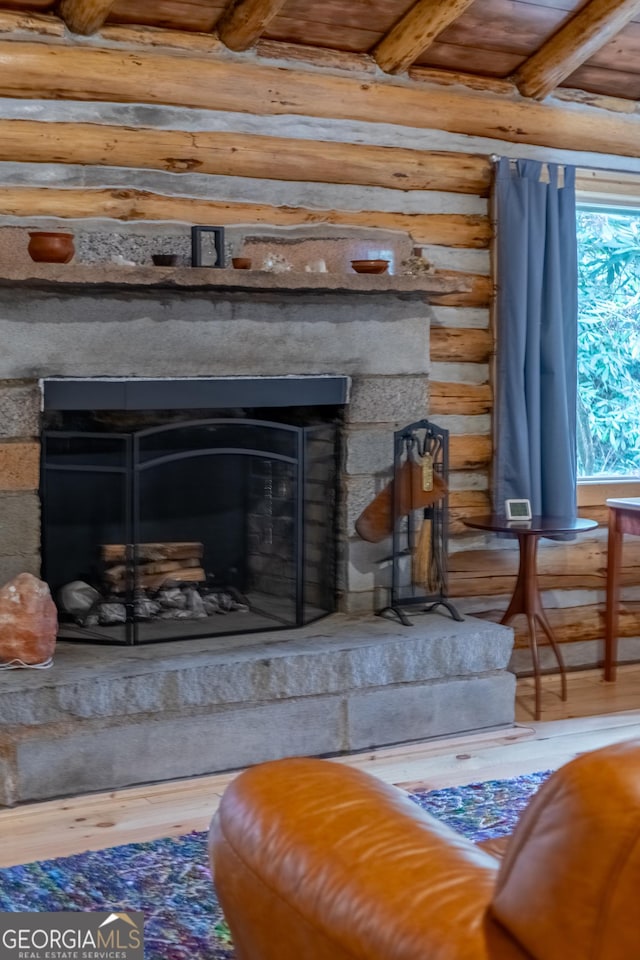 room details featuring wood-type flooring, a fireplace, and log walls