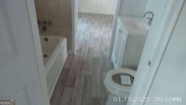 bathroom featuring toilet, hardwood / wood-style flooring, and vanity