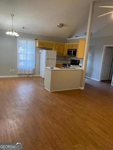 kitchen featuring dark hardwood / wood-style flooring, lofted ceiling, and hanging light fixtures