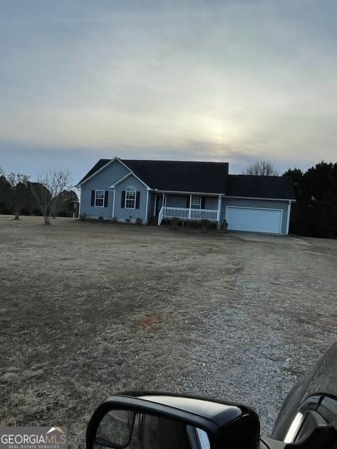 ranch-style house featuring covered porch and a garage