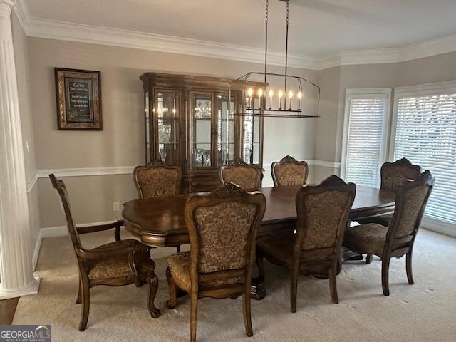 dining area featuring light colored carpet, a notable chandelier, and ornamental molding