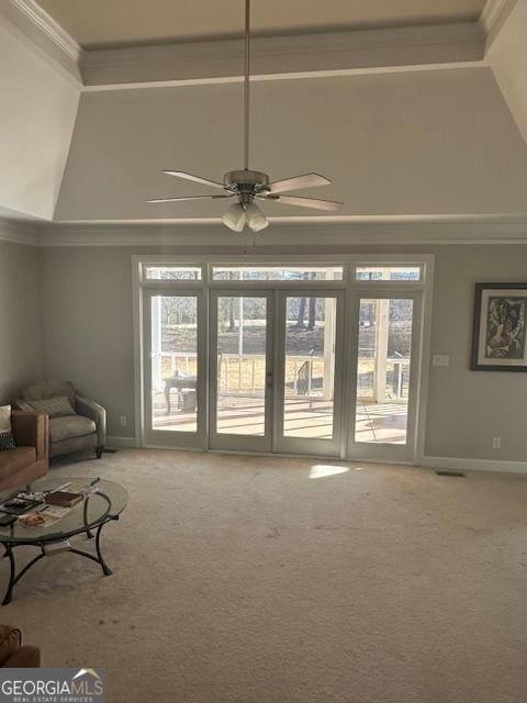 unfurnished living room featuring ceiling fan, a healthy amount of sunlight, ornamental molding, and carpet flooring