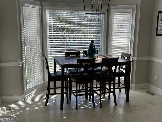 dining space with plenty of natural light and a notable chandelier