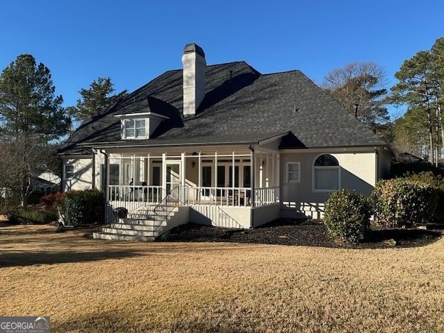 rear view of property with a sunroom