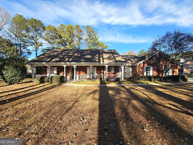 ranch-style house with a front lawn and covered porch