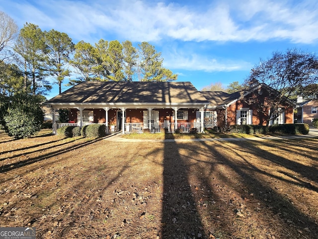 single story home with a porch and a front yard