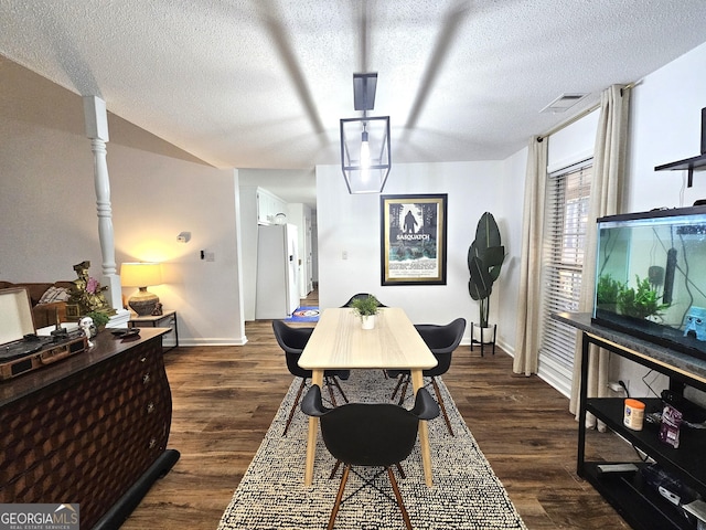 dining area featuring dark hardwood / wood-style floors and a textured ceiling