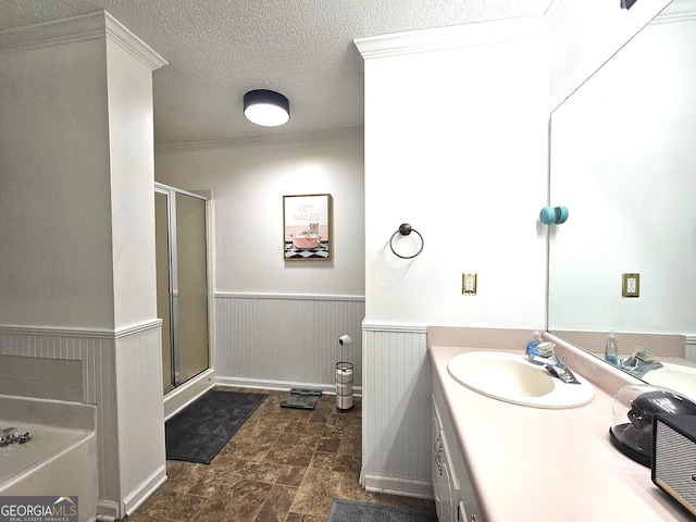 bathroom with a shower with door, a textured ceiling, vanity, and ornamental molding