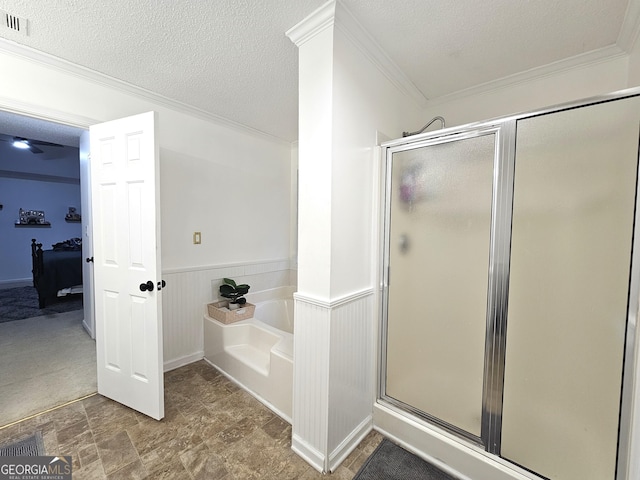 bathroom with a textured ceiling, crown molding, and independent shower and bath