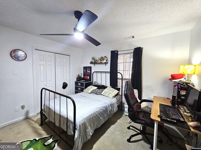 bedroom with a textured ceiling, carpet flooring, a closet, and ceiling fan