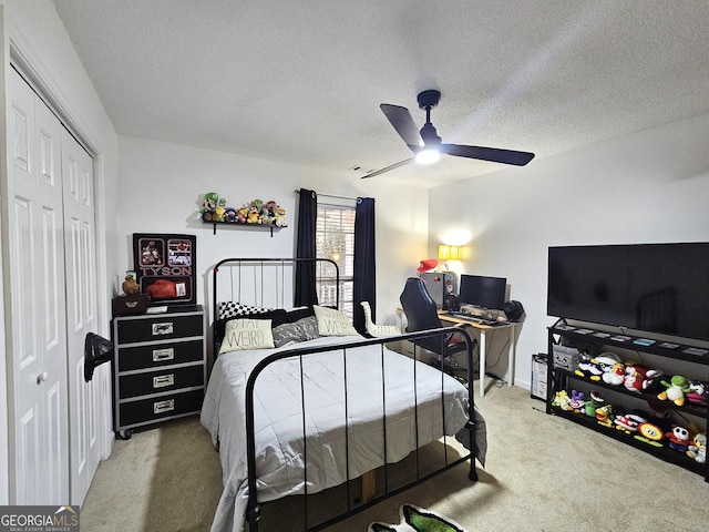 bedroom with ceiling fan, a textured ceiling, a closet, and carpet