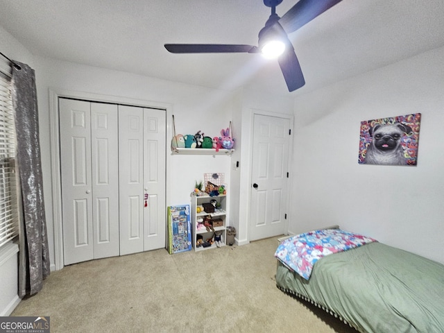 carpeted bedroom featuring ceiling fan and a closet