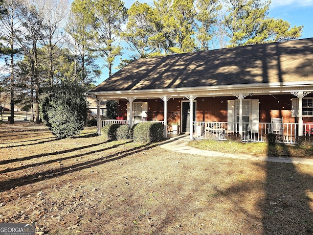 view of front of home with covered porch and a front lawn