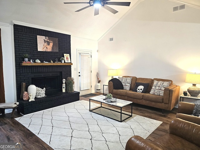 living room featuring a fireplace, hardwood / wood-style floors, crown molding, and vaulted ceiling