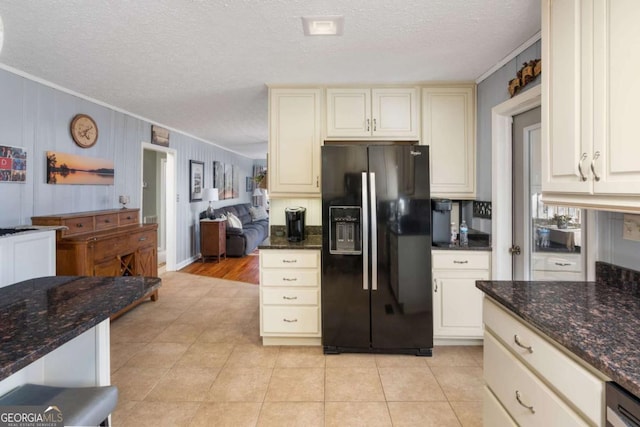 kitchen with a textured ceiling, black refrigerator with ice dispenser, dark stone counters, light tile patterned floors, and crown molding