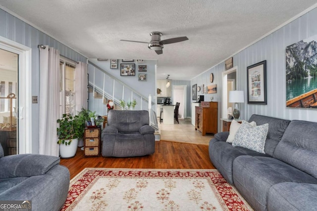 living room with a textured ceiling, dark wood-type flooring, plenty of natural light, and ceiling fan