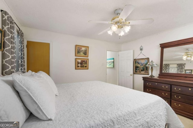 bedroom with ceiling fan and a textured ceiling