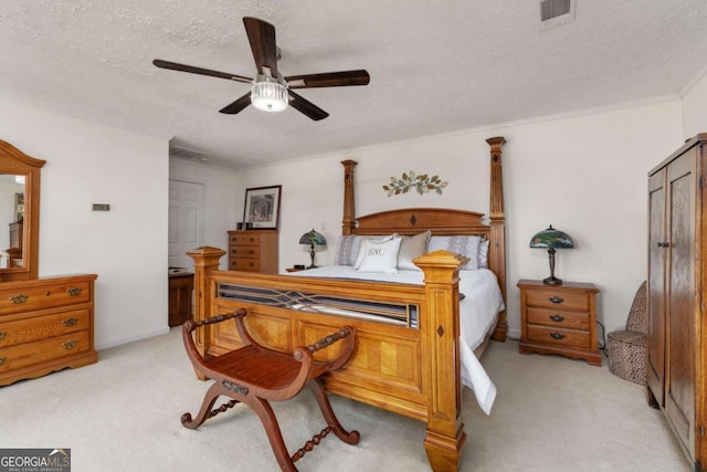 bedroom with ceiling fan, light colored carpet, crown molding, and a textured ceiling