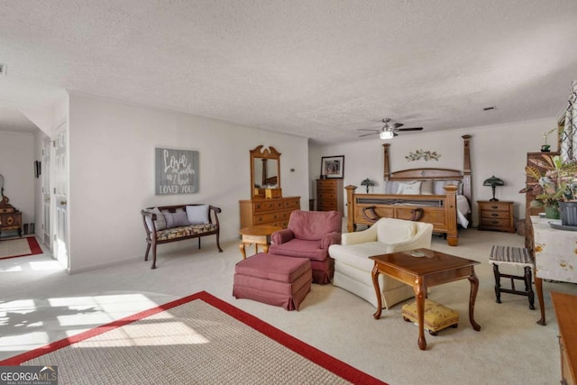 carpeted bedroom with ceiling fan and a textured ceiling