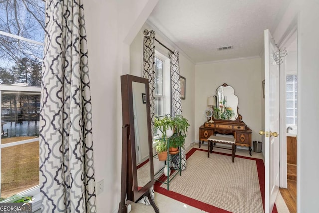 hallway with a textured ceiling and crown molding