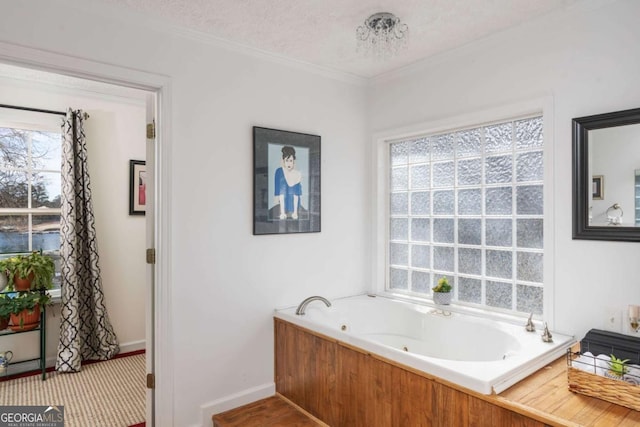 bathroom featuring a textured ceiling, crown molding, and a tub