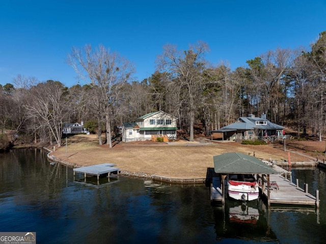 view of dock with a water view and a yard