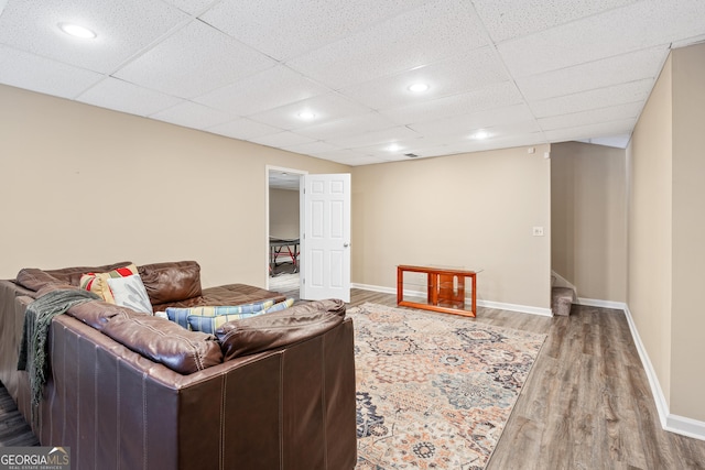 living room featuring hardwood / wood-style flooring and a drop ceiling