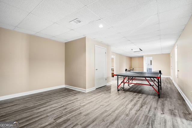 game room with a paneled ceiling and hardwood / wood-style floors