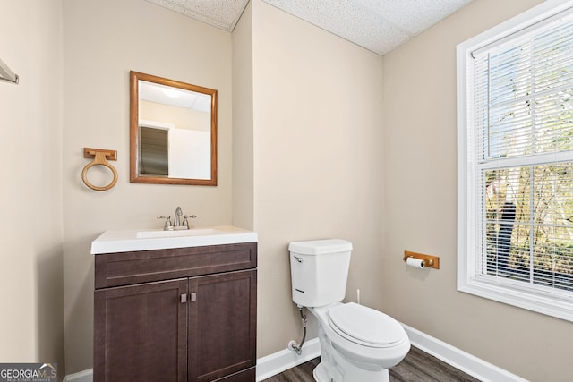 bathroom with toilet, hardwood / wood-style flooring, and vanity