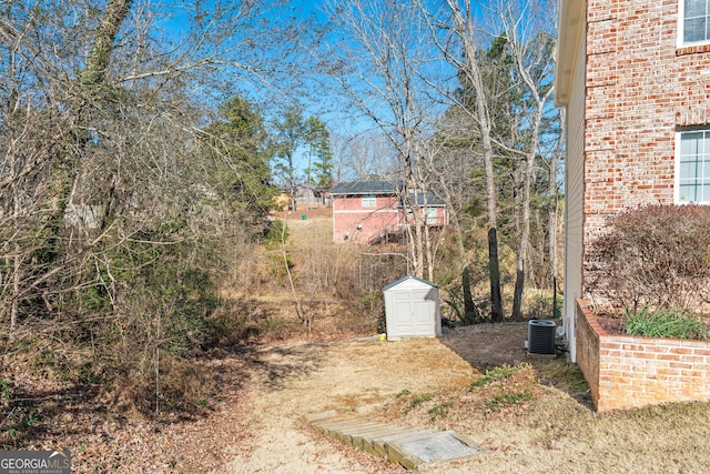 view of yard featuring central AC unit and a shed