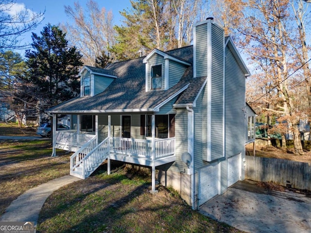 view of front facade with a front yard, covered porch, and a garage