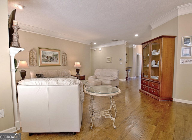 living room with dark wood-type flooring, ornamental molding, and a textured ceiling