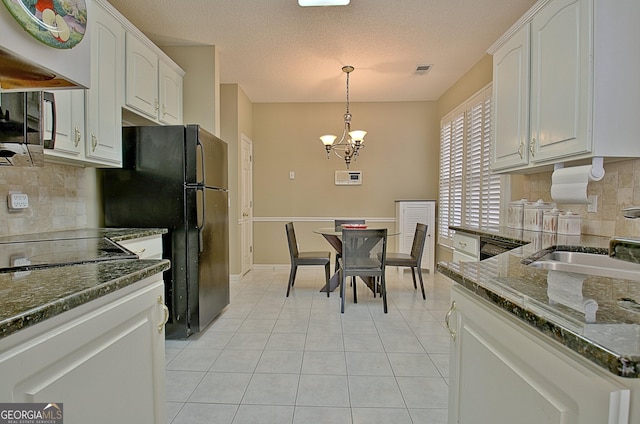 kitchen featuring light tile patterned floors, decorative light fixtures, sink, and white cabinets