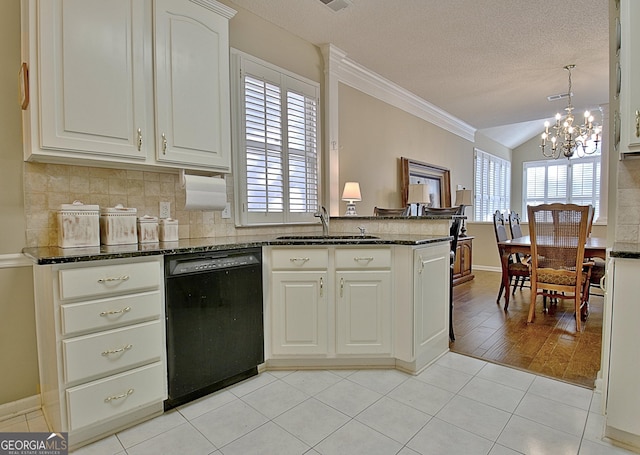 kitchen featuring sink, decorative light fixtures, dark stone countertops, black dishwasher, and white cabinets