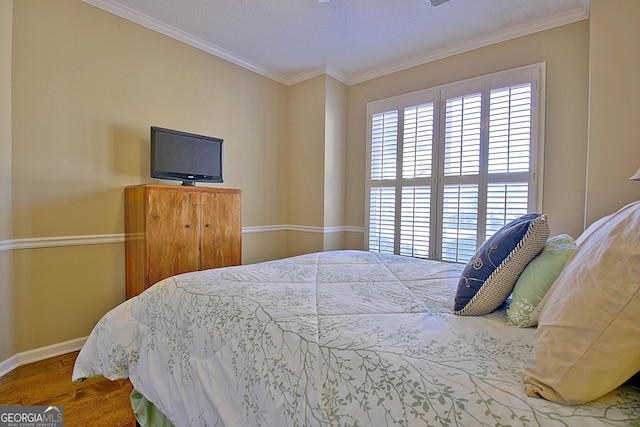 bedroom with crown molding and hardwood / wood-style floors